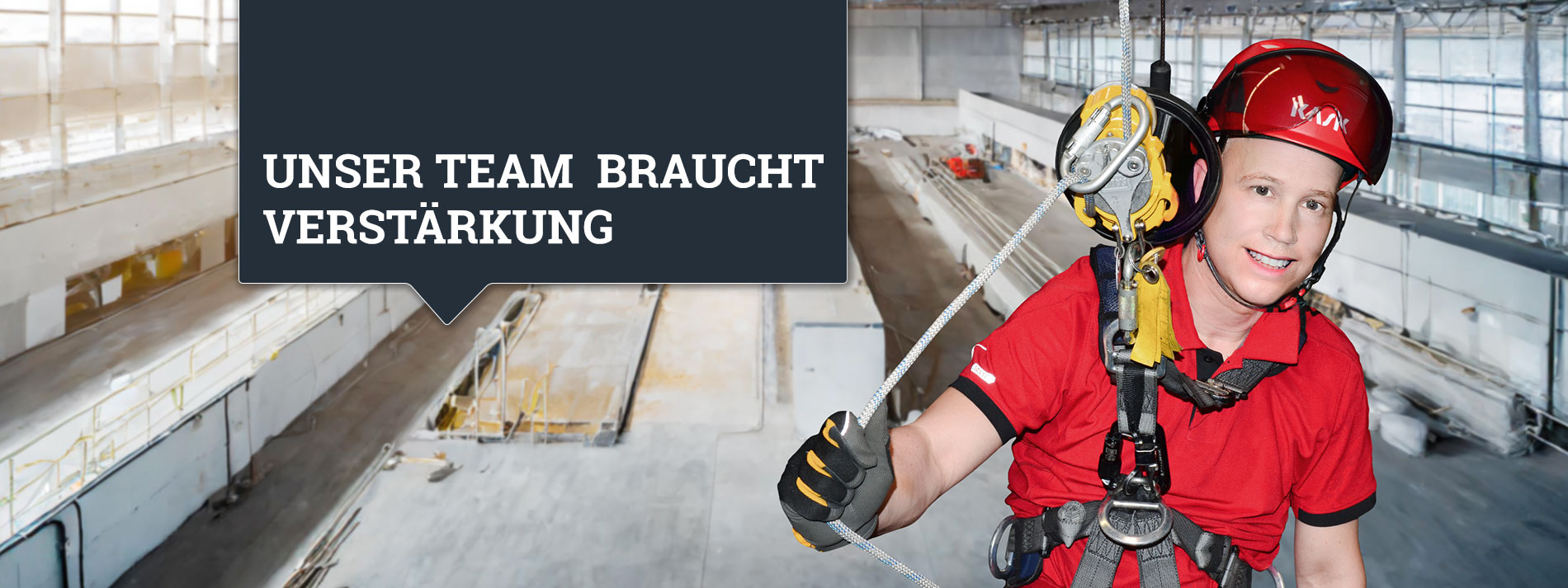 Klettender Trainer mit Helm und Ausrüstung in einer großen Höhe