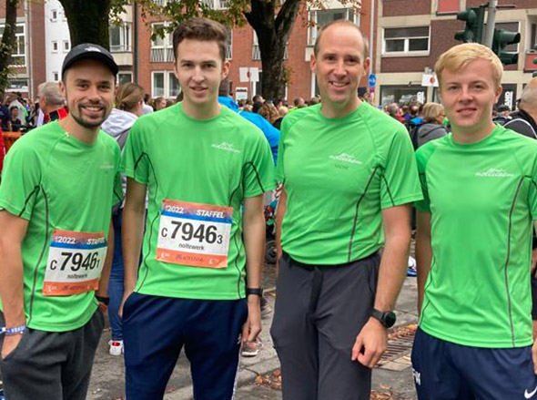 Vier Männer in hellgrünen T-Shirts mit Startnummern für den Staffelmarathon in Münster 2022